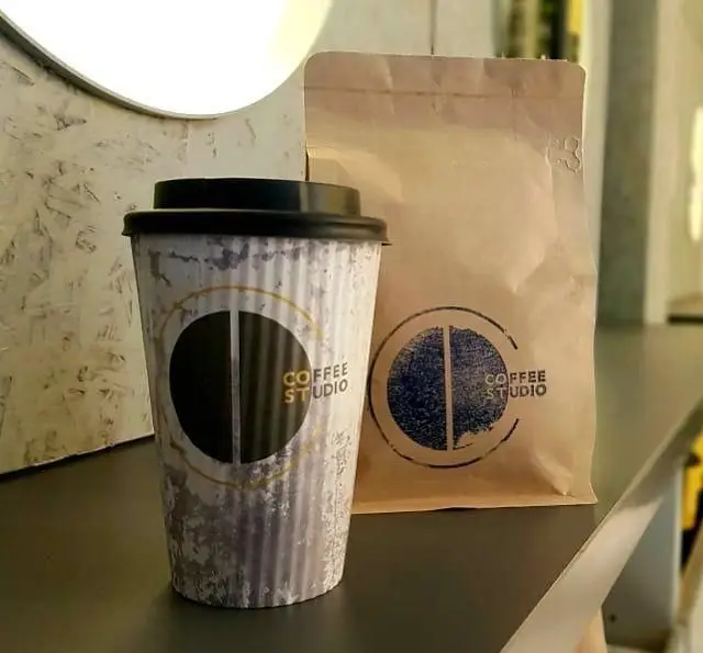 لیوان کاغذی و بسته قهوه کرافت با لوگو و نام تجاری استدیو قهوه. محصولاتی جذاب برای کافه و فروشگاه قهوه تخصصی.