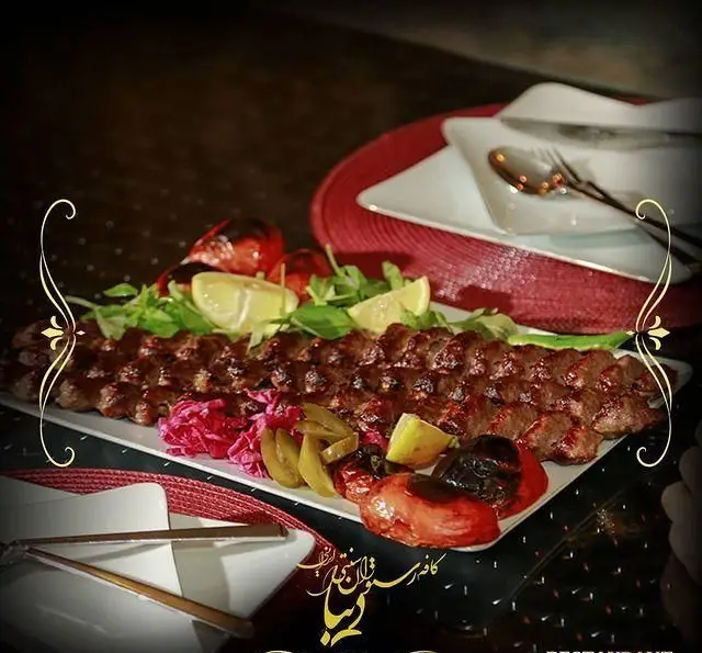 کباب کوبیده لذیذ رستوران سنتی دیبا، یک غذای اصیل ایرانی با گوجه کبابی و دورچین تازه. تجربه طعم بی‌نظیر در کافه رستوران دیبا.
