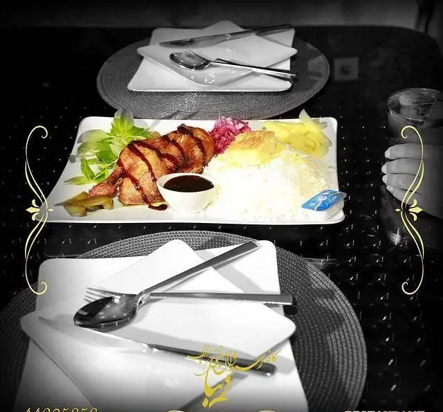 یک پرس غذای لذیذ شامل مرغ با سس، چلو و دورچین در محیط دلنشین کافه رستوران سنتی دیبا، ارائه دهنده طعم اصیل ایرانی.