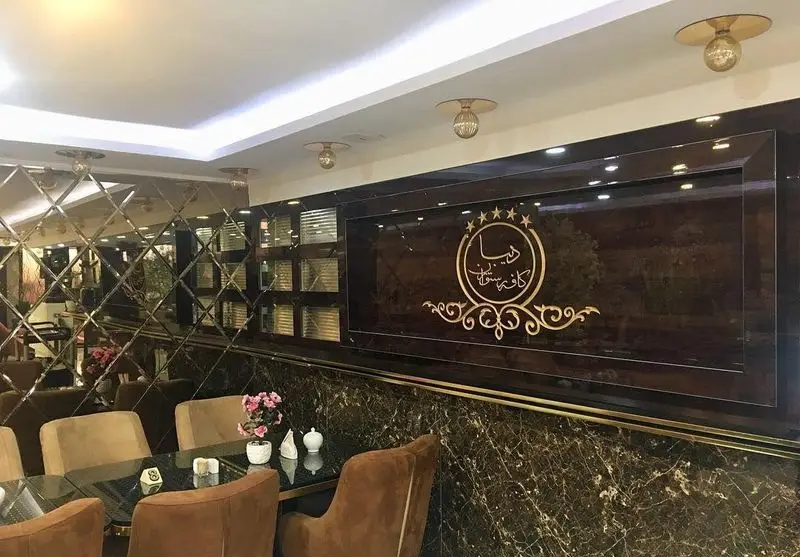 نمای داخلی کافه رستوران سنتی دیبا با دکوراسیون لوکس، دیوار آینه کاری، میز و صندلی‌های شیک و لوگوی برند. محیطی دلنشین برای مشتریان.
