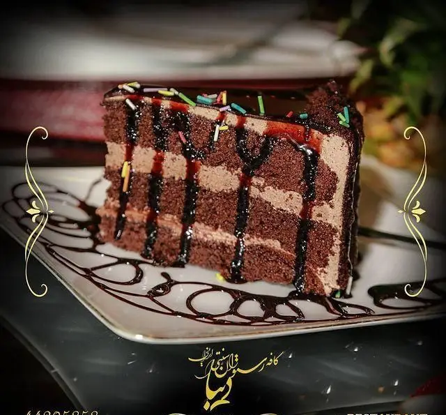 کیک شکلاتی سه لایه با فیلینگ کرم کاکائویی و سس شکلات، دسری خاص و پرطرفدار از منوی کافه رستوران سنتی دیبا در فضایی دلنشین.
