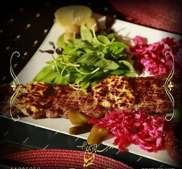 یک پرس کباب لذیذ ایرانی سرو شده با کره، همراه با سبزی خوردن تازه، خیارشور و کلم ترشی قرمز در کافه رستوران سنتی دیبا