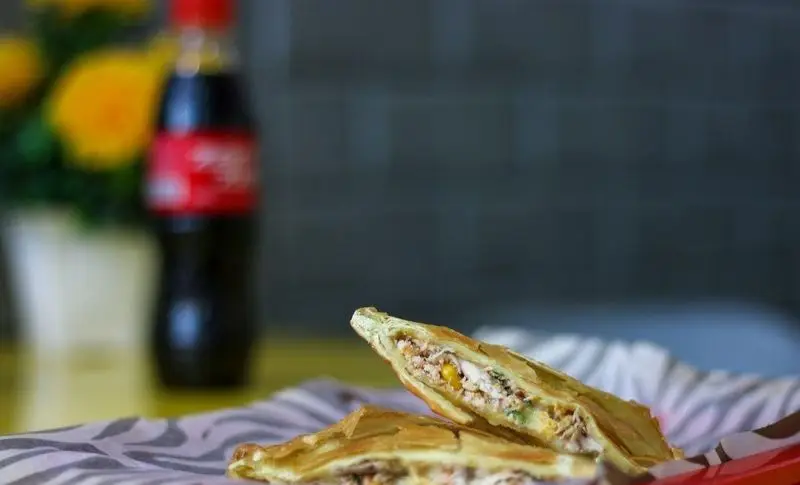 ساندویچ کریسپی و خوشمزه مرغ و ذرت فست فود میلاد، در بسته‌بندی زیبا و آماده برای سرو، انتخابی عالی برای یک وعده غذایی لذیذ و سریع.