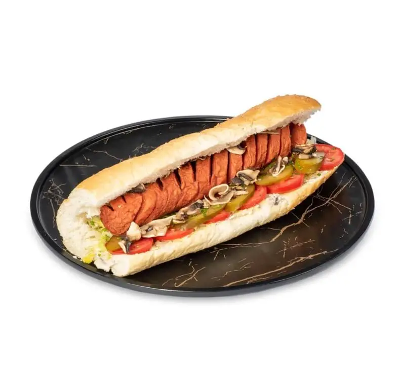 ساندویچ هات داگ ویژه و لذیذ فست فود کامنت با سوسیس دودی برش‌خورده، قارچ، خیارشور، گوجه، کاهو و نان باگت تازه.