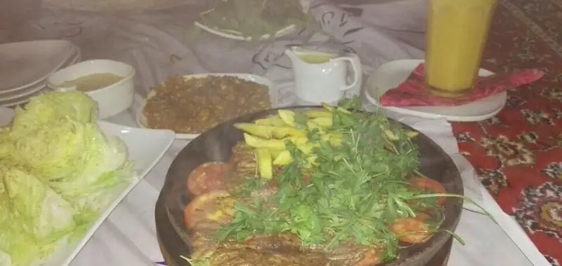 میز غذای چیده شده در رستوران فرنگی آبی با استیک داغ، سیب زمینی سرخ کرده، سالاد و نوشیدنی خنک برای تجربه ای دلپذیر.