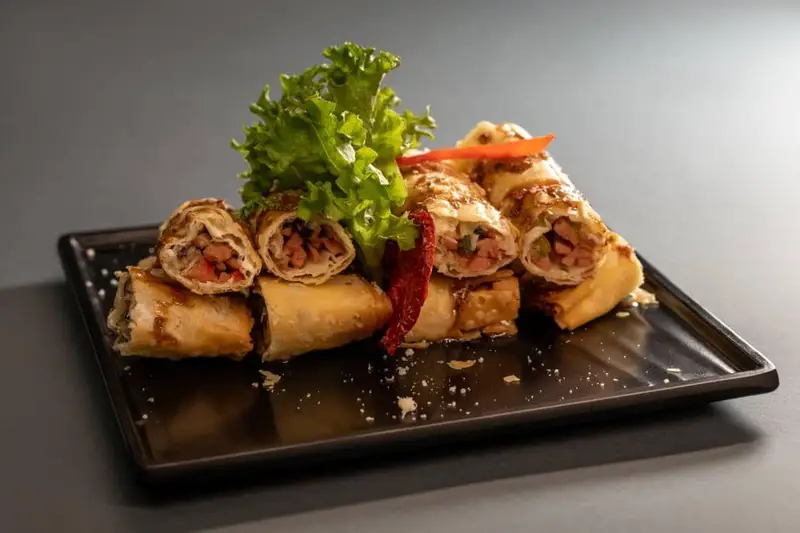 رول‌های سرخ شده خوشمزه با فیلینگ سوسیس و سبزیجات، یک فینگرفود عالی از منوی کافه رستوران هاید لانژ، مناسب هر سلیقه.