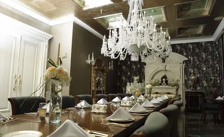 دکوراسیون شیک و مجلل کافه رستوران شاندیز گالریا با میز پذیرایی چیده شده، لوستر باشکوه و گل آرایی زیبا برای رویدادها.