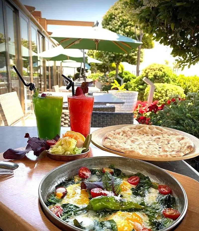 صبحانه دلنشین در کافه رستوران شاندیز گالریا با فضای باز سرسبز، نوشیدنی‌های خنک، املت و نان تازه. محیطی عالی برای لذت.