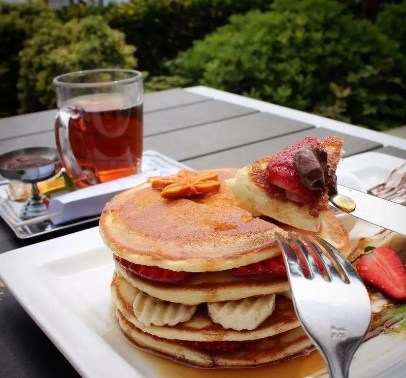پنکیک توت فرنگی، نوتلا و خامه در منوی صبحانه کافه رستوران شاندیز گالریا. لذت یک صبحانه کامل با چای در فضای سرسبز.