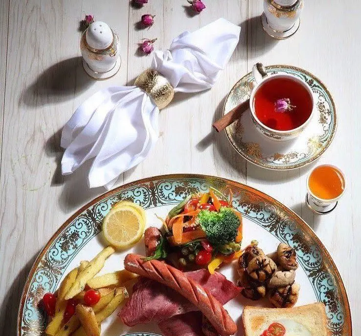 صبحانه مجلل و متنوع کافه رستوران شاندیز گالریا شامل سوسیس، قارچ، سالاد، سیب زمینی، نان تست، دمنوش و آبمیوه در محیطی دلنشین.