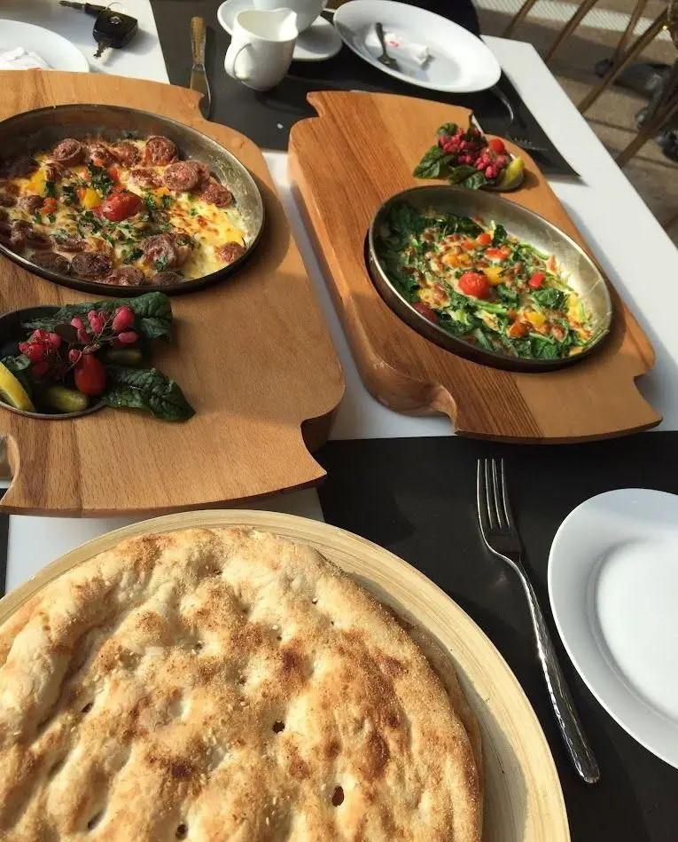 صبحانه خوشمزه و متنوع کافه رستوران شاندیز گالریا شامل املت سوسیس و پنیر، املت سبزیجات و نان تازه داغ. تجربه‌ای لذیذ.