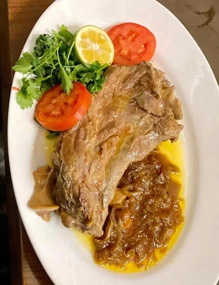 یک بشقاب خوراک گوشت نرم و خوش‌طعم با سس مخصوص، پیاز کاراملی، گوجه و لیمو. کافه رستوران شاندیز گالریا، تجربه غذای ایرانی.