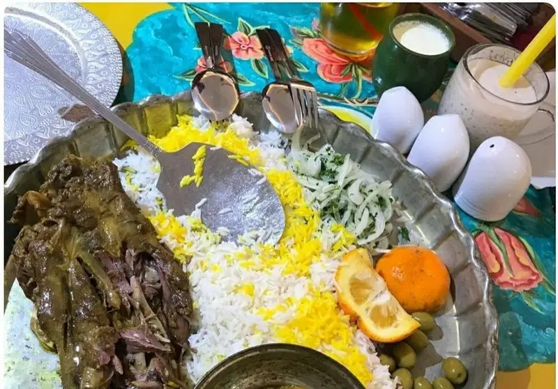 غذای اصیل ایرانی گوشت با برنج، پیاز، سبزی، زیتون و مرکبات در رستوران مرشد باهنر. همراه با دوغ.