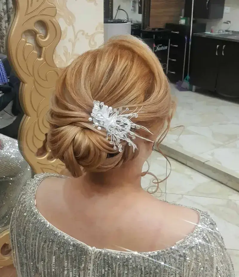 جدیدترین مدل شینیون موی بسته عروس با موهای بلوند و اکسسوری درخشان نقره‌ای در سالن زیبایی و آرایشگاه تخصصی موی تهران