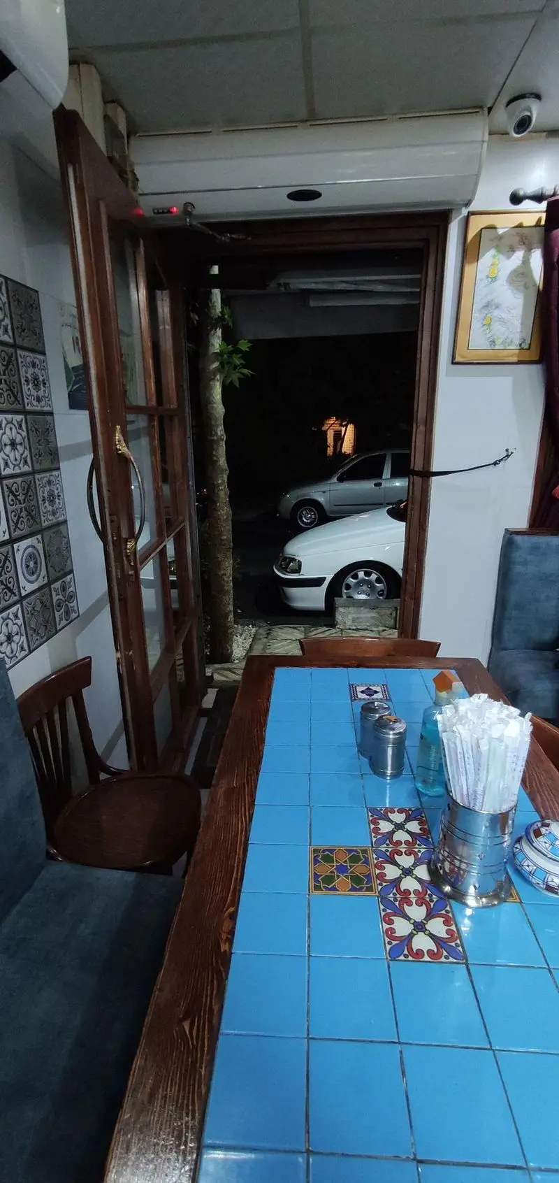 فضای داخلی قیمه سرای عمو هوشنگ با میز کاشی‌کاری آبی و دکوراسیون گرم و صمیمی، تجربه‌ای دلنشین برای صرف قیمه و غذاهای ایرانی.