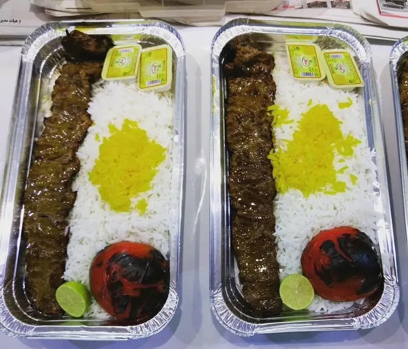 غذای لذیذ رستوران طوبی: کباب کوبیده اصیل ایرانی با برنج زعفرانی، گوجه کبابی، کره و لیمو در بسته بندی آماده.