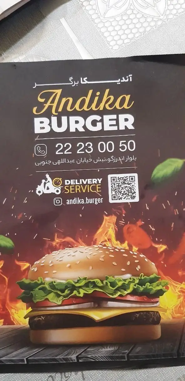 تصویر تبلیغاتی فست فود اندیکا برگر شامل یک همبرگر لذیذ، اطلاعات تماس (22230050)، آدرس و خدمات دلیوری.