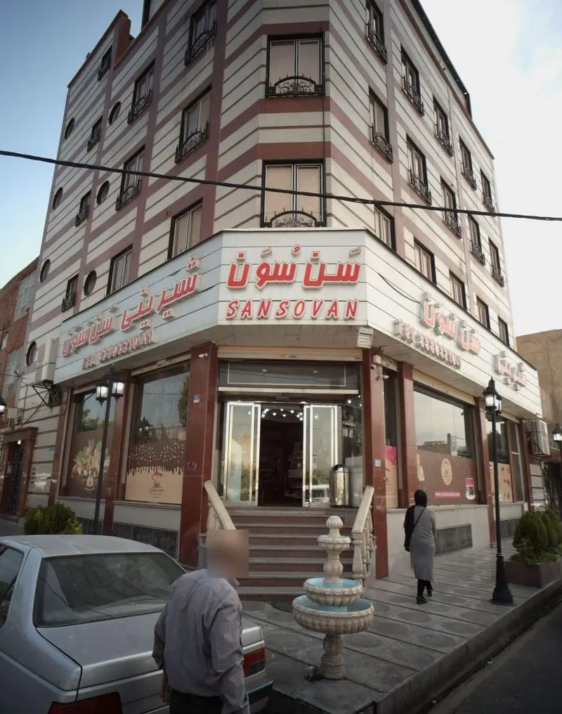 نمای بیرونی شیرینی سن سون، قنادی و شیرینی فروشی مدرن در یک ساختمان چند طبقه، با تابلوهای فارسی و انگلیسی SANSOVAN.