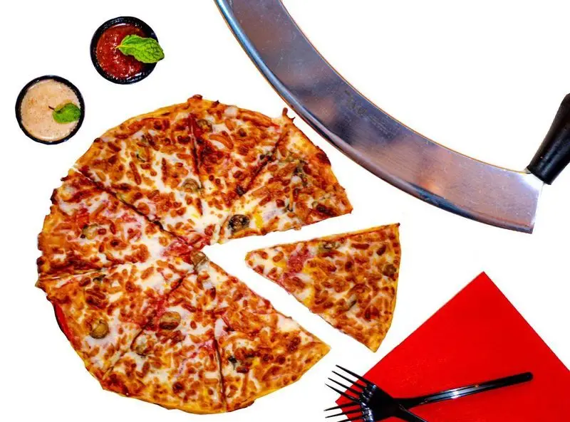 پیتزا قارچ و پنیر برش خورده از منوی کافه فست فود برج برگر، همراه با سس‌های خوش‌طعم و کاتر پیتزا، آماده سفارش و سرو.