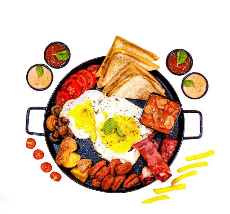 سینی صبحانه انگلیسی کامل و متنوع کافه فست فود برج برگر با نیمرو، بیکن، سوسیس، قارچ، گوجه، سیب زمینی و نان تست تازه.