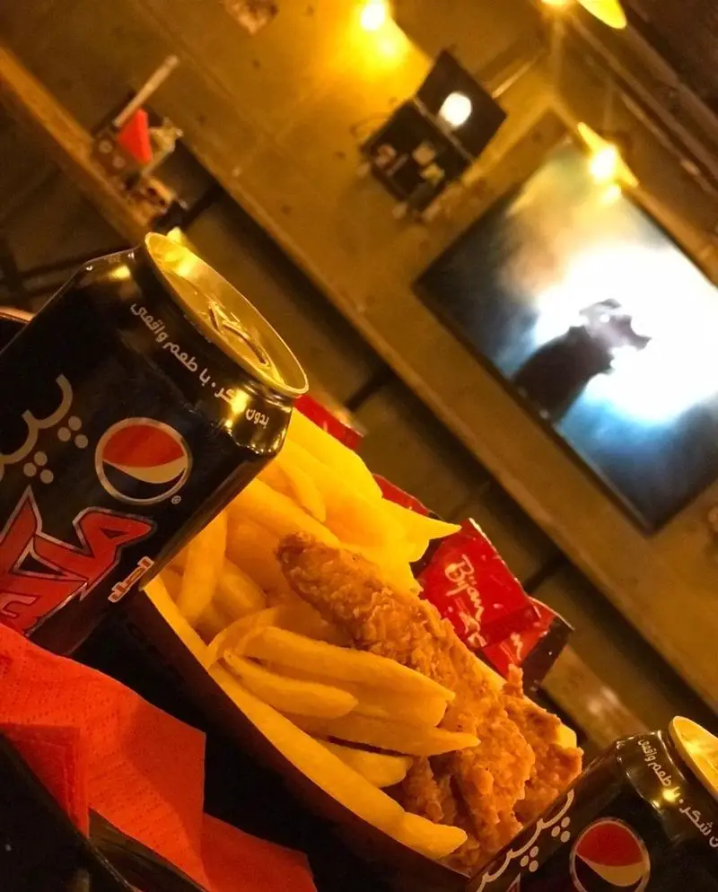 سفارش جذاب پپسی مکس، سیب زمینی سرخ کرده و مرغ سوخاری در کافه فست فود برج برگر با فضایی گرم و دلنشین، تجربه غذایی لذت‌بخش.