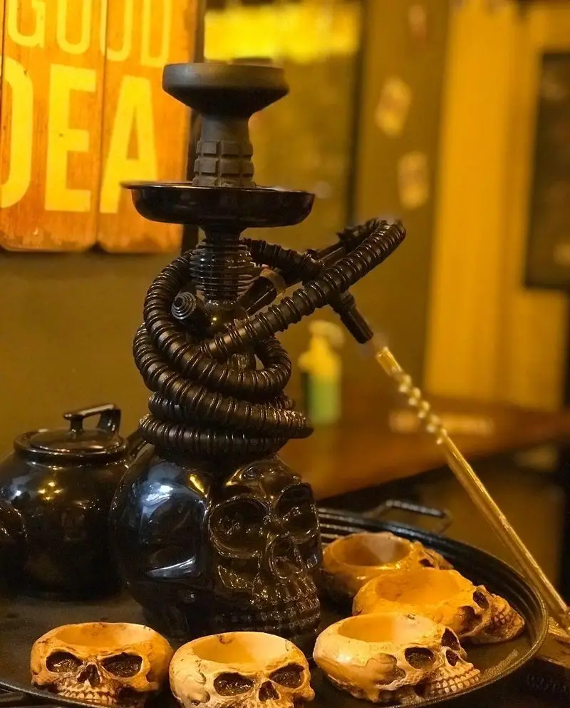 تصویری جذاب از قلیان جمجمه‌ای مشکی و دکوراسیون خاص کافه فست فود برج برگر، فضایی منحصربه‌فرد برای مشتریان.