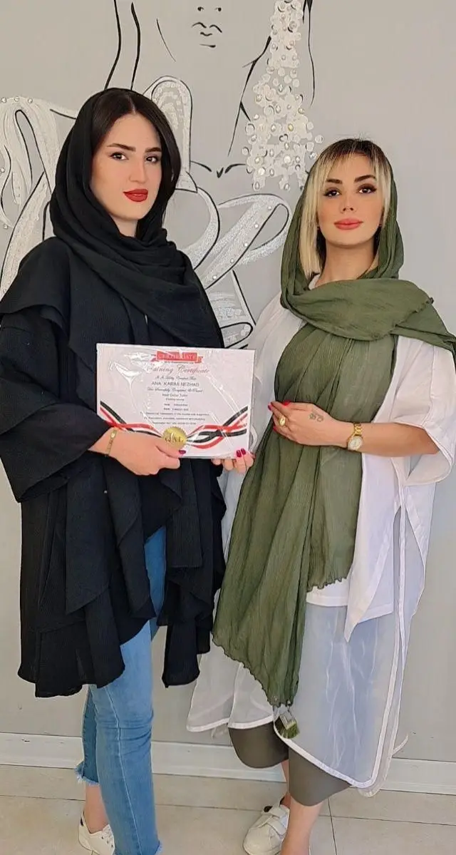 دو زن با پوشش مانتو و روسری در حال ارائه مدرک بینالمللی دوره آموزشی آرایشگری در سالن و آرایشگاه زنانه پریسا اتابکی