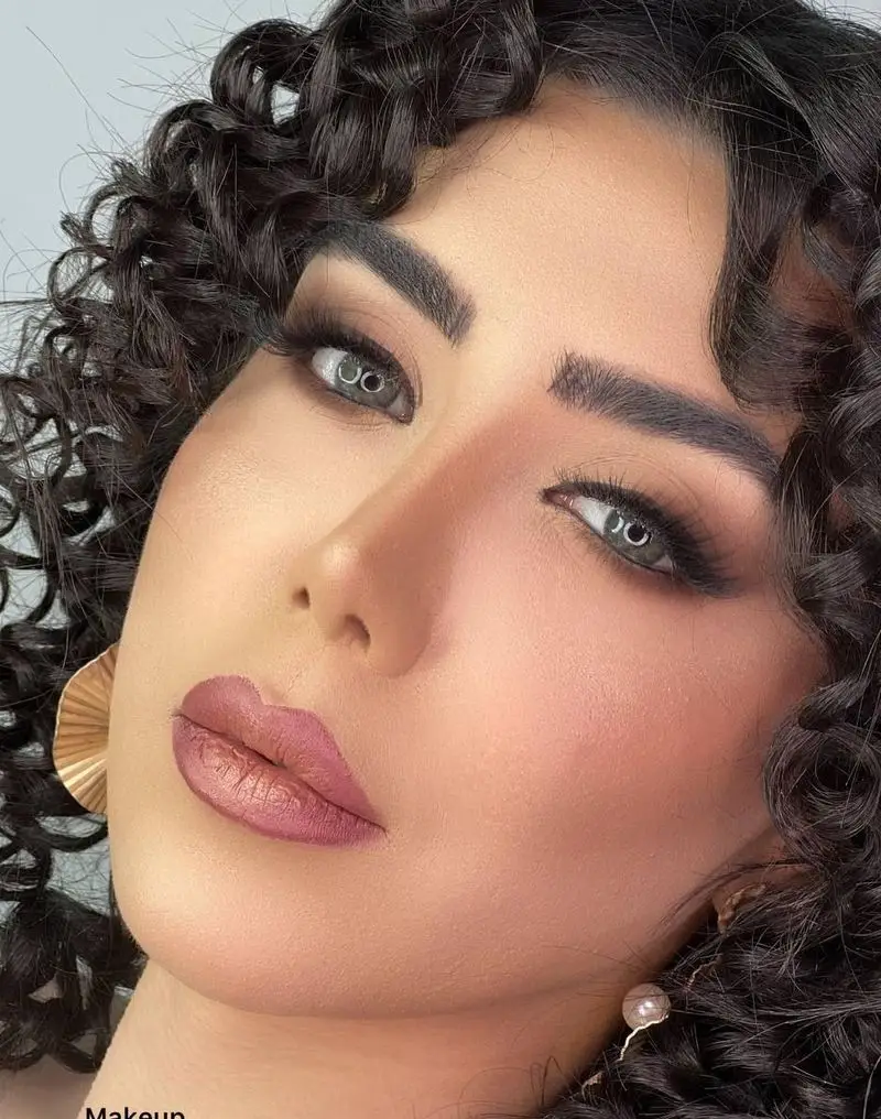 مدل آرایش صورت زنانه با موهای فر مشکی، سایه چشم اسموکی و رژ لب کالباسی در سالن زیبایی و آرایشگاه زنانه پریسا اتابکی