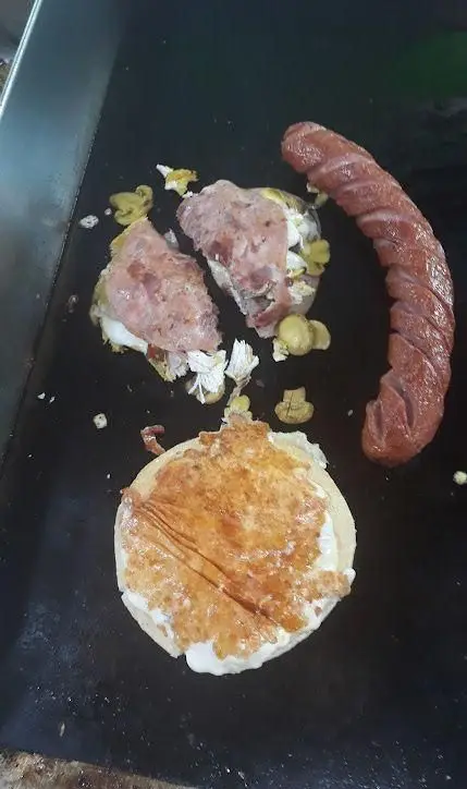 تصویری از آماده‌سازی ویژه برگر، سوسیس گریل شده و مواد اولیه تازه ساندویچ در گریل مجموعه برگر ویژه تین.