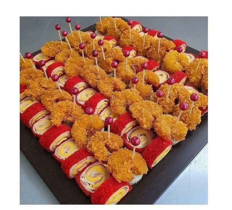 سینی فینگر فود گرم و متنوع شامل ناگت سوخاری طلایی و رول‌های قرمز رنگ با فیلینگ پنیر، مناسب مهمانی‌ها و پذیرایی خاص.