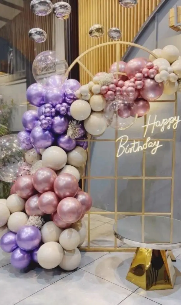 فضای جشن تولد بی‌نظیر کافه رستوران گجا با بادکنک‌آرایی زیبا و بنفش، صورتی و سفید، ایده‌آل برای ساخت لحظات خاطره‌انگیز.