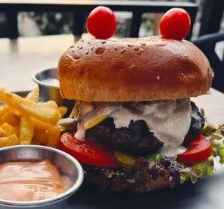 برگر لذیذ و خلاقانه با دیزاین خرچنگی مخصوص کافه رستوران گجا، همراه سیب زمینی سرخ کرده و سس. تجربه‌ی غذایی جذاب در گجا.