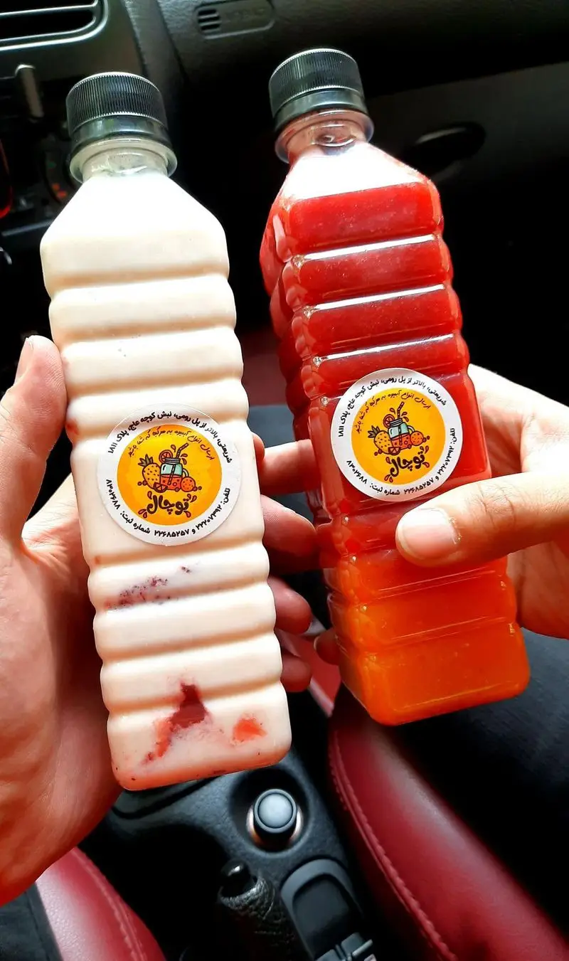 دو بطری خوشمزه آب میوه طبیعی توچال با طعم های توت فرنگی (شیر توت فرنگی) و میکس میوه قرمز، نوشیدنی تازه و انرژی بخش.