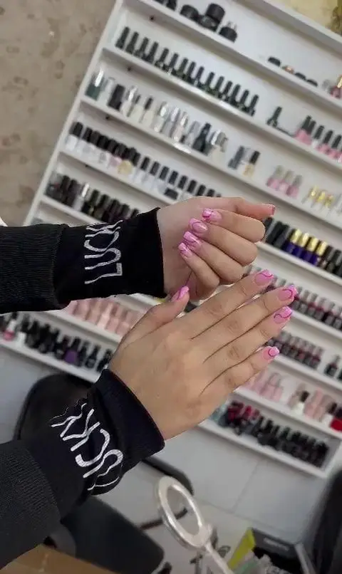 جدیدترین مدل طراحی ناخن دخترانه با لاک ژل صورتی ملایم و طرحهای خطی مواج و شیک در سالن تخصصی کاشت و ژلیش ناخن