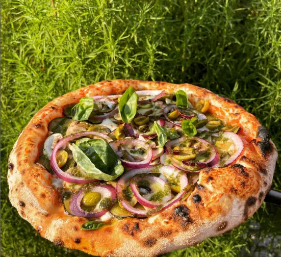 پیتزای ایتالیایی اصیل آشپزخانه هارمونی با خمیر پفکی، روکش پیاز قرمز، زیتون، ریحان و سس پستو، تجربه‌ای بی‌نظیر.