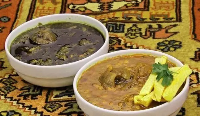 خورشت قورمه سبزی و قیمه لذیذ در رستوران ایرانی اسلیمی، سرو شده با سیب‌زمینی سرخ شده روی فرش سنتی ایرانی.