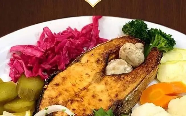 ماهی گریل شده خوش‌طعم با قارچ، بروکلی و هویج بخارپز، همراه ترشی کلم قرمز و خیارشور در رستوران ایرانی اسلیمی.