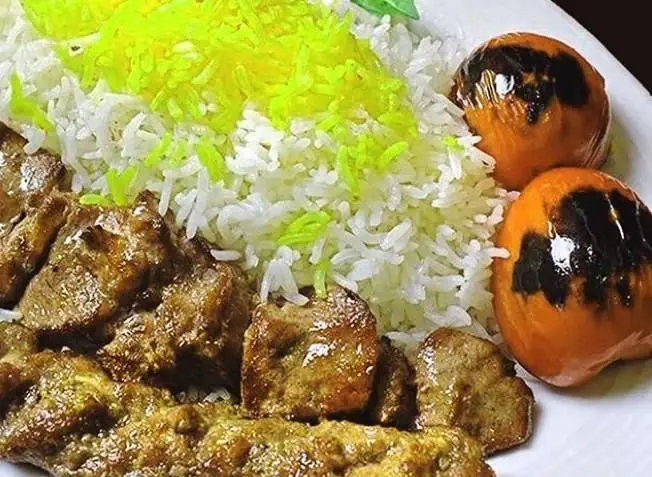 چلوکباب ممتاز رستوران اسلیمی شامل برنج زعفرانی، کباب گوشت و گوجه کبابی. بهترین غذای سنتی ایرانی برای تجربه ای دلنشین.