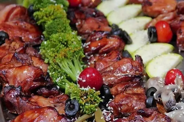 غذای لذیذ رستوران ایرانی اسلیمی: سینی کامل مرغ طعم‌دار، بروکلی، زیتون، قارچ و گوجه تازه برای یک تجربه بی‌نظیر.