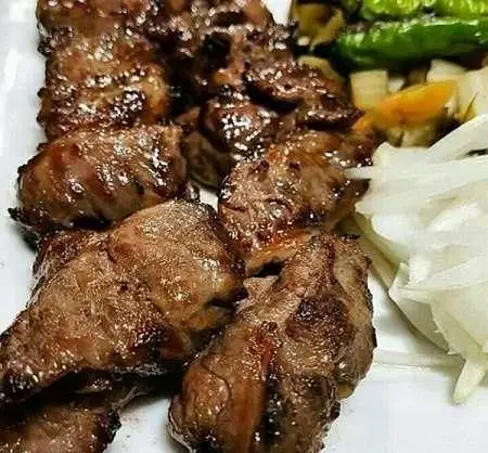 کباب گوشت آبدار و خوشمزه کترینگ پارسی همراه با پیاز و فلفل سبز، آماده برای سفارش آنلاین غذای ایرانی و مجالس.