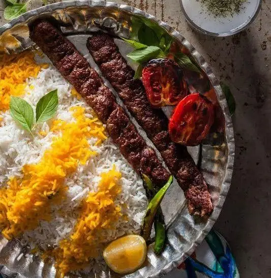 کباب کوبیده لذیذ کترینگ پارسی با چلو زعفرانی، گوجه کبابی، ریحان و ماست؛ غذای اصیل ایرانی برای تجربه ای دلنشین.