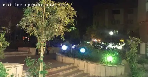 کباب خانه دورچین در شب: فضای سبز دلنشین با نورپردازی آرامش‌بخش، درختان و چراغ‌های تزئینی، محیطی ایده‌آل.