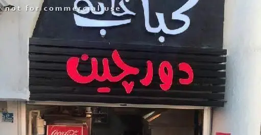 تابلو سردر کباب خانه دورچین با فونت فارسی و نورپردازی جذاب، نام کسب و کار رستوران ایرانی را به نمایش می‌گذارد.