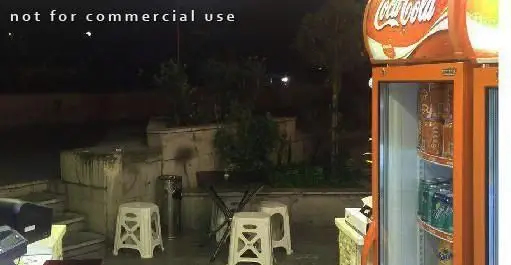 تصویری از محیط بیرونی و دنج کباب خانه دورچین در تاریکی شب، مجهز به یخچال نوشیدنی و مبلمان راحتی برای صرف کباب.