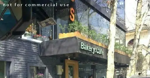 نمای خارجی شیک و جذاب رستوران فرنگی سبوس و کافه نانوایی آن با پنجره‌های بزرگ، گیاهان سبز و تابلوی Bakery.Cafe.