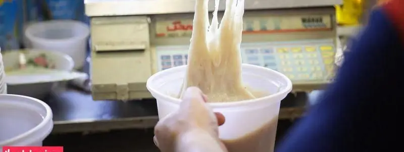 تهیه دسر سنتی (شبیه فالوده) در لیوان توسط گروه غذایی حاج علی و پسران، بافتی کشدار و لذیذ برای مشتریان.