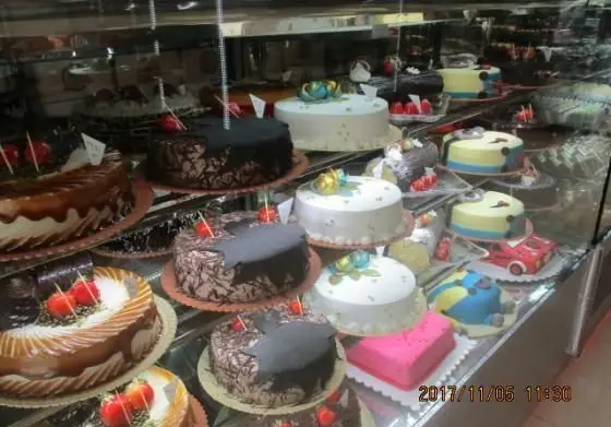 ویترین جذاب شیرینی پدیده شرق با انواع کیک‌های تولد و مجلسی زیبا و خوشمزه، از کیک شکلاتی تا طرح‌های خاص و مدرن.