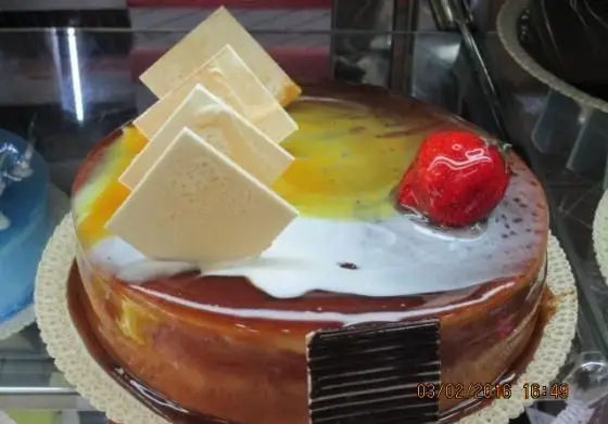 کیک مجلسی و خوشمزه شیرینی پدیده شرق با روکش شکلاتی و میوه‌ای، تزئین شده با توت فرنگی و شکلات سفید برای جشن‌ها و تولد.