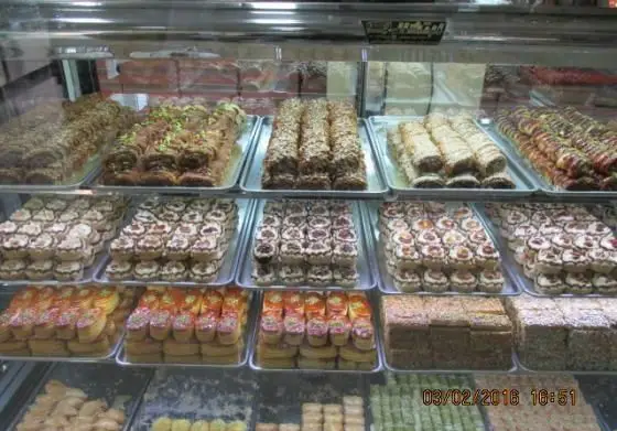 تصویری از ویترین جذاب شیرینی پدیده شرق با مجموعه ای متنوع از باقلوا، شیرینی های سنتی و دسرهای تازه و لذیذ.