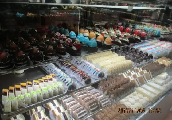 ویترین رنگارنگ و پر از انواع شیرینی‌های تازه و خوشمزه شیرینی پدیده شرق، شامل کیک، دسر و شیرینی‌های تر برای هر سلیقه‌ای.